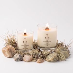 Vela aromática Golden Tundra acesa, em pote de vidro com pavio de madeira