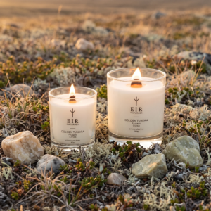 Velas aromáticas Golden Tundra da EIR Naturals, 50g e 190g acesas sobre solo de tundra em luz dourada com textura mineral